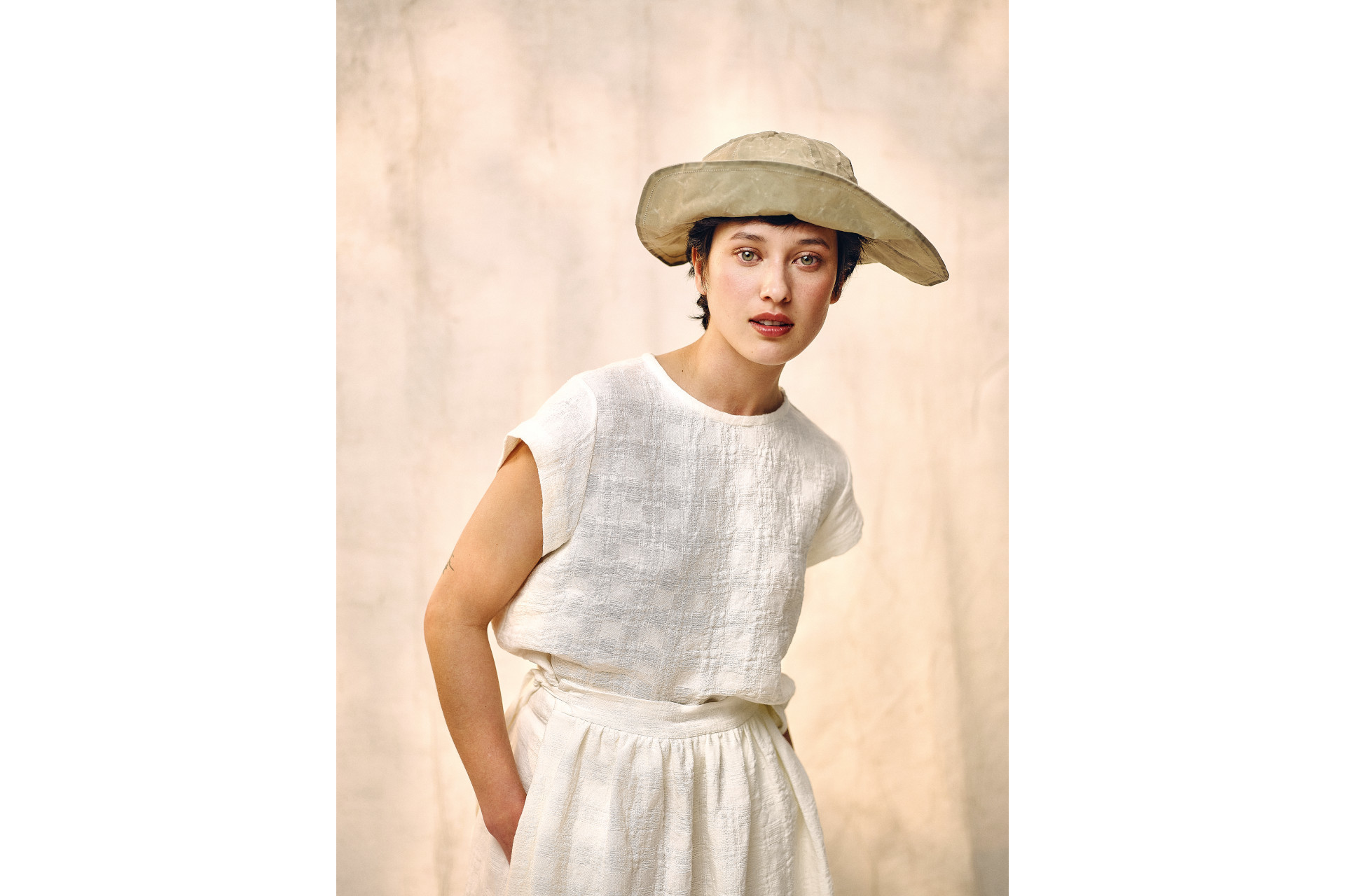 Woman in white top and trousers and straw hat
