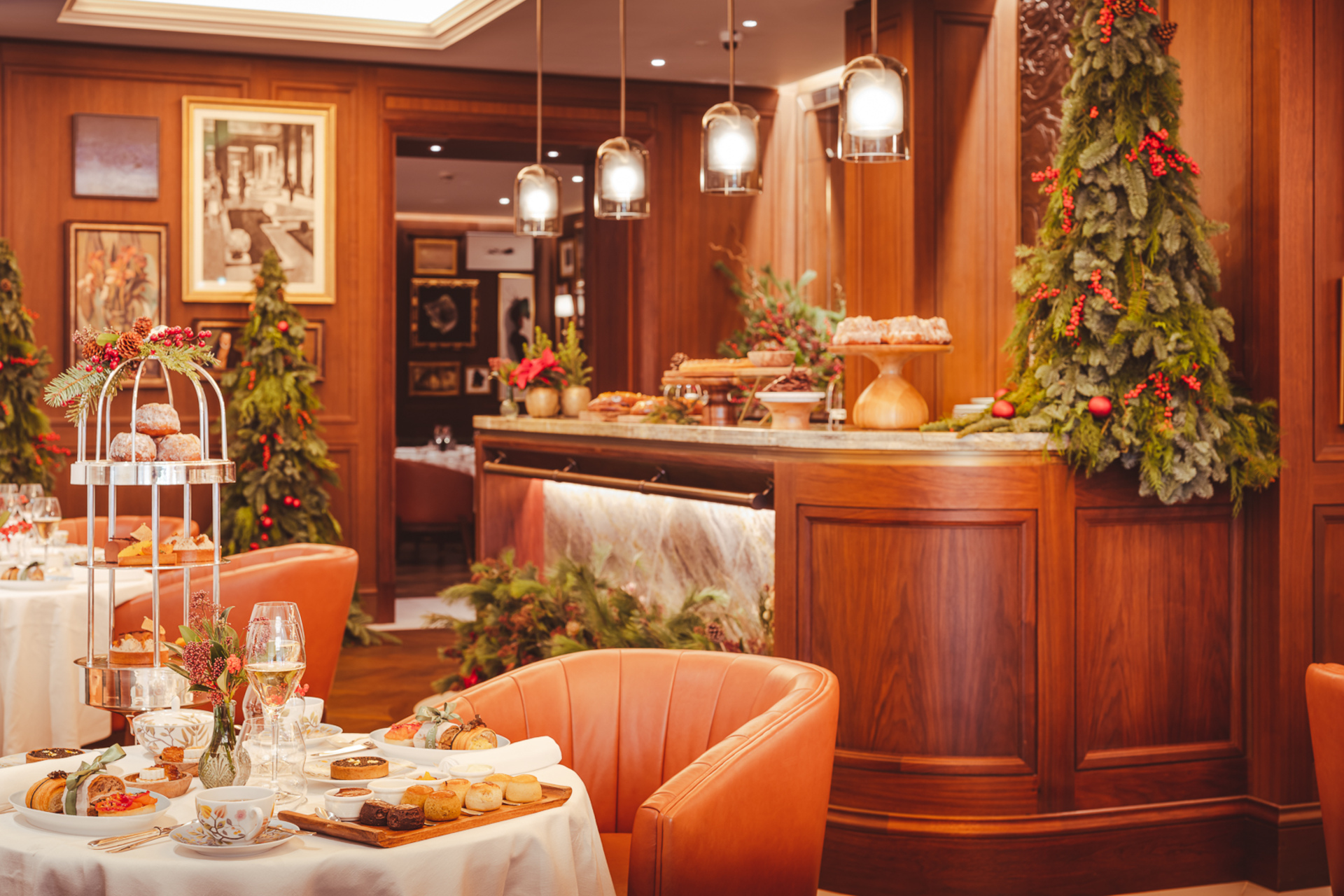 Table set with afternoon tea in front of bar decorated with small Christmas trees