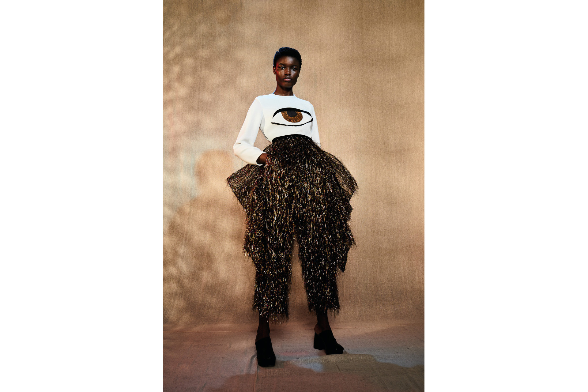 Woman in ruffled print trousers and white tee