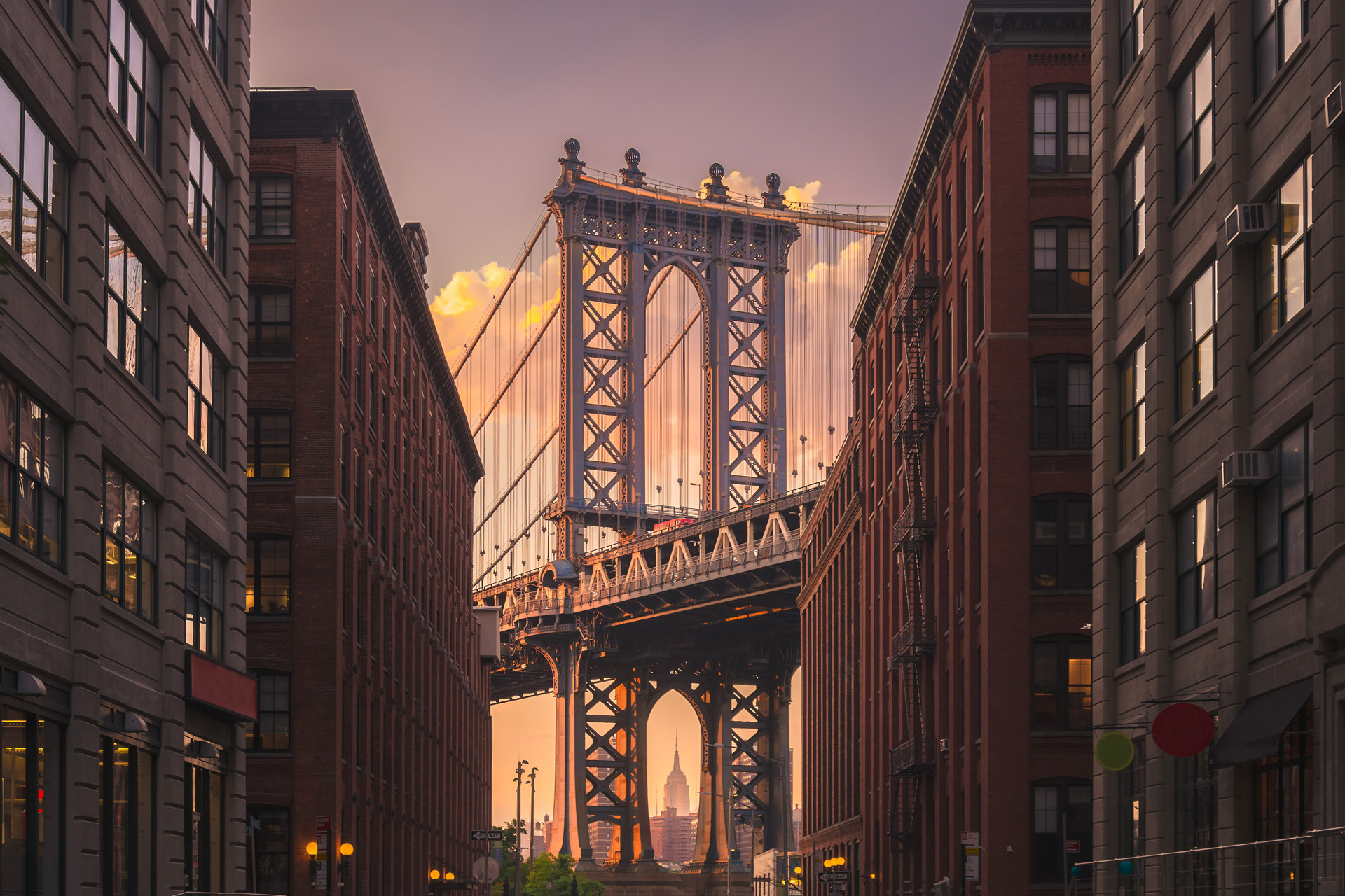 Manhattan bridge seen from a brick buildings in Brooklyn street in perspective, New York, USA. Shot in the evening