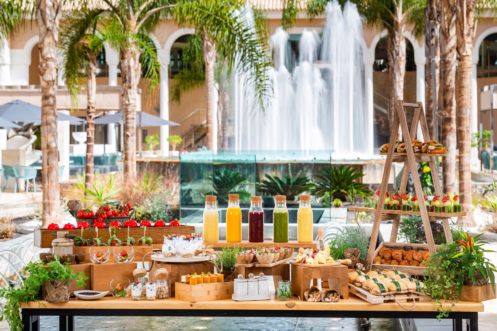 breakfast banquet with colorful juices and waterfall fixture in the background