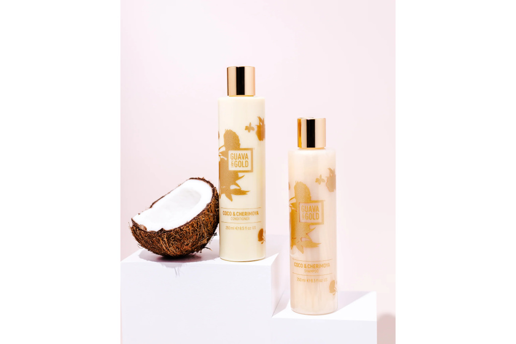Cream and gold haircare bottles next to coconut - Christmas beauty gifts
