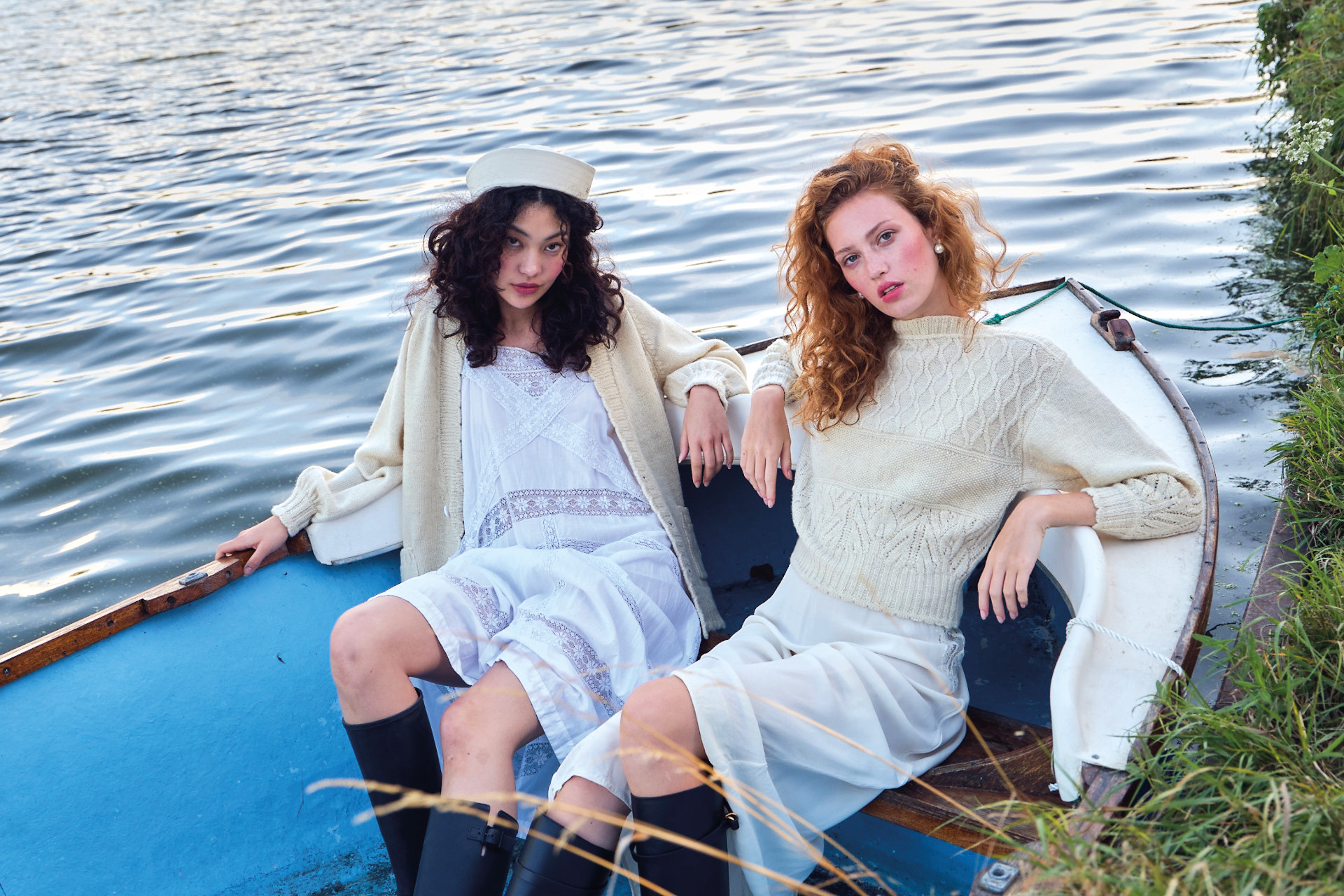 Two women sat in a boat on a countryside canal