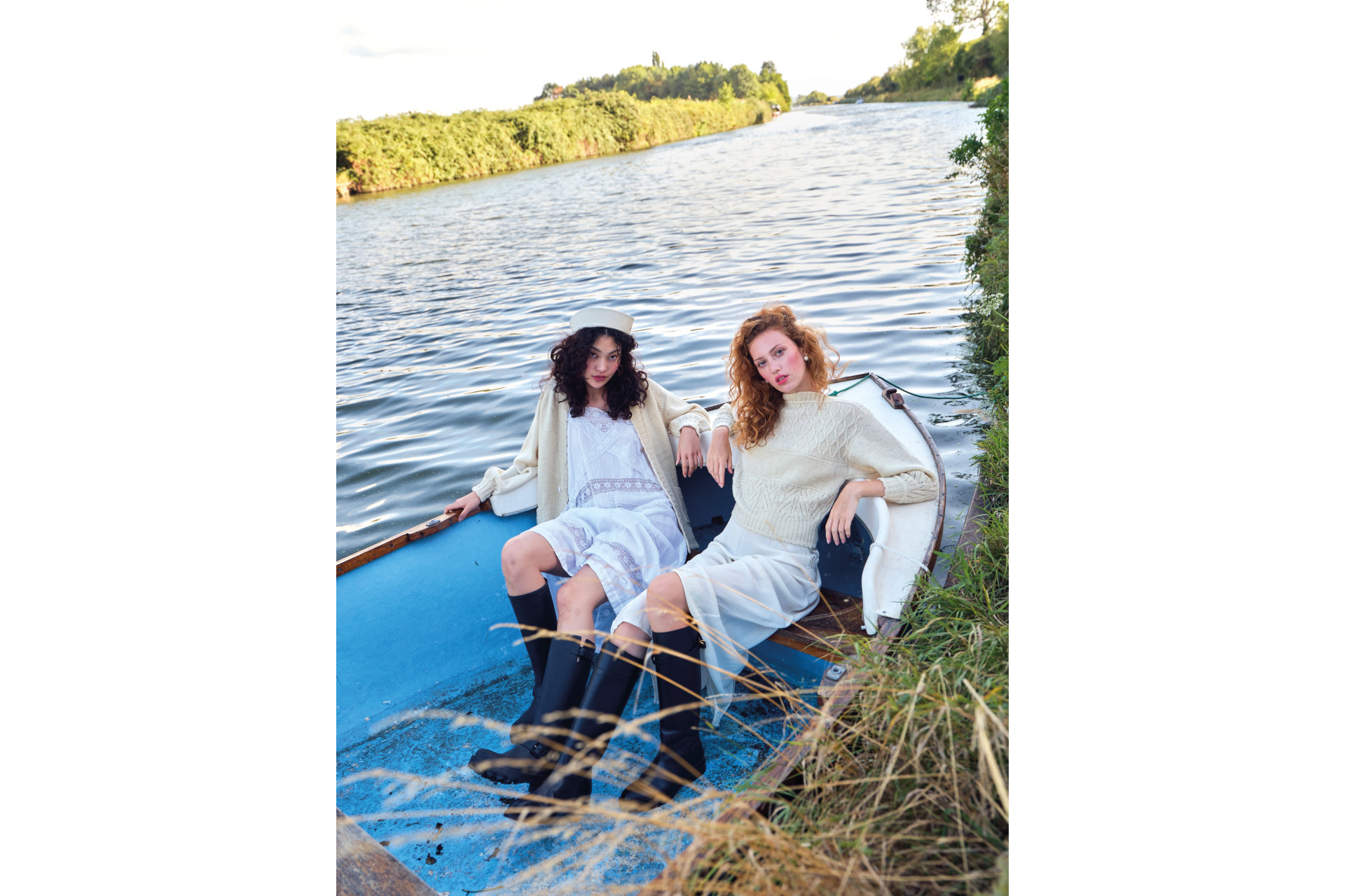 Two women sat in a boat on a countryside canal