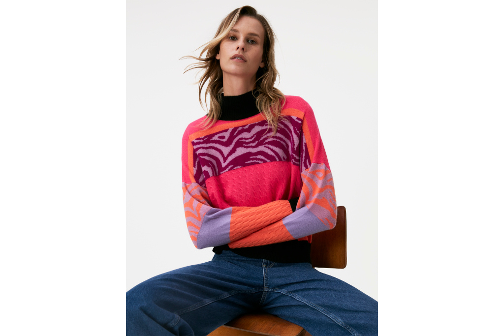 Woman in patterned jumper sat on chair