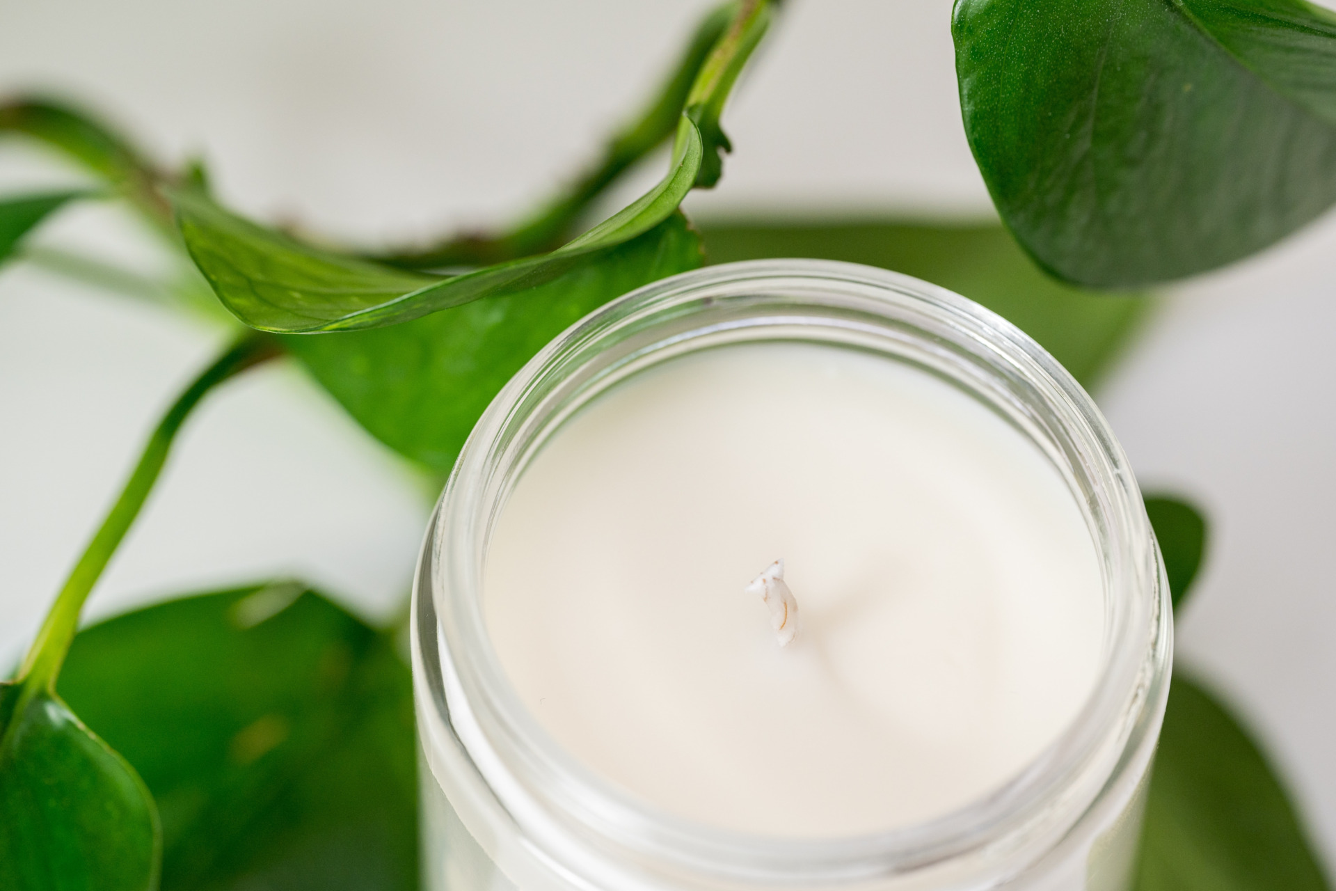 Glass jar candle next to leaves