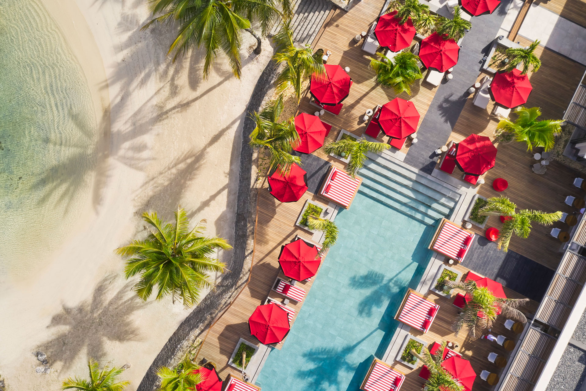 Hotel Ocean front with red beach umbrellas and sunbeds 