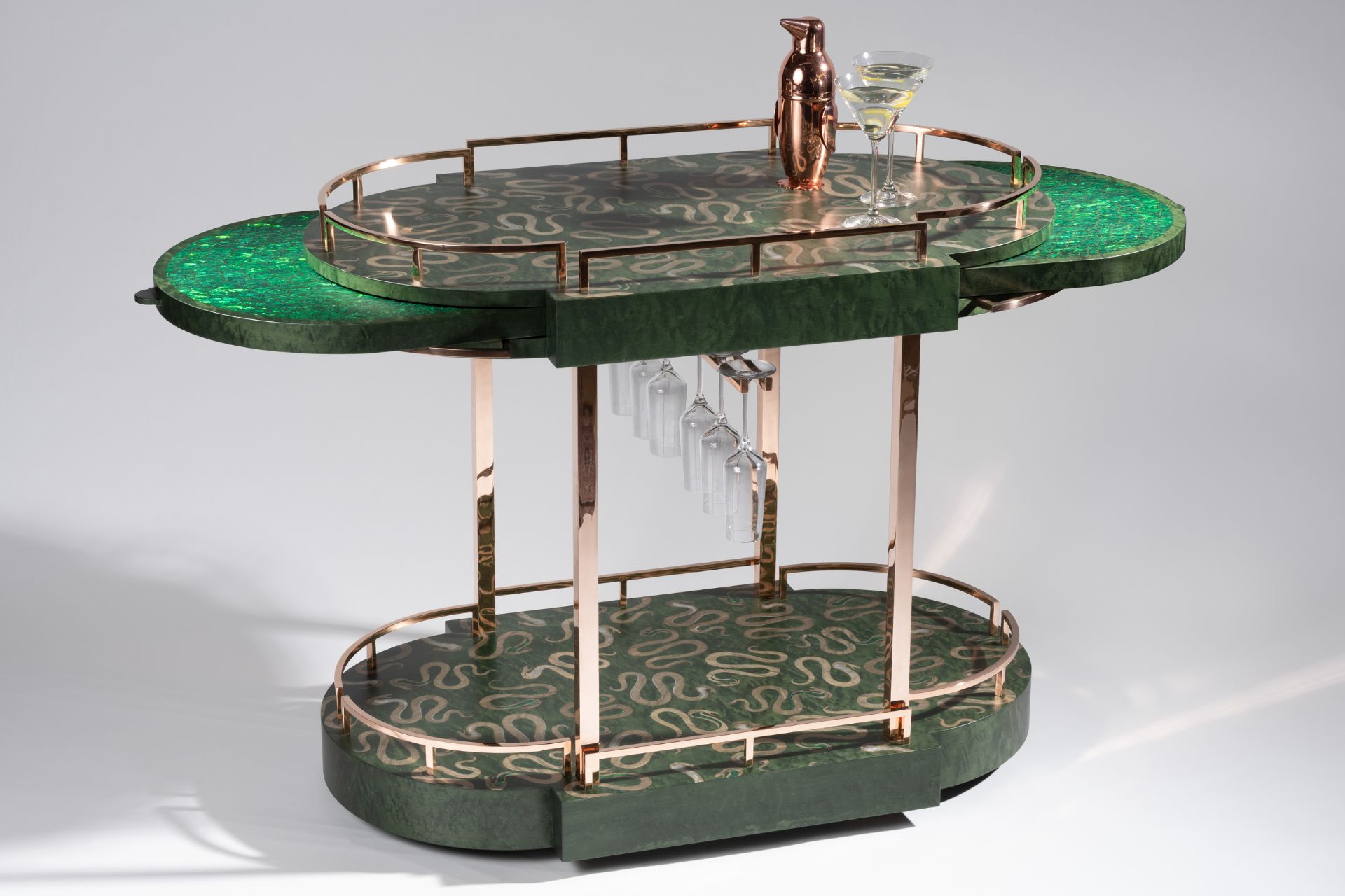 Green bar cart with pull-out shelves and curved bronze handles.