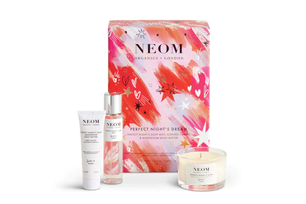 Pink box next to bottles and candle - Christmas beauty gifts