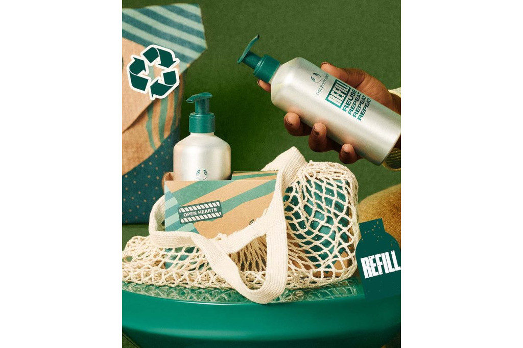 Hands holding bottle around net bag on green background