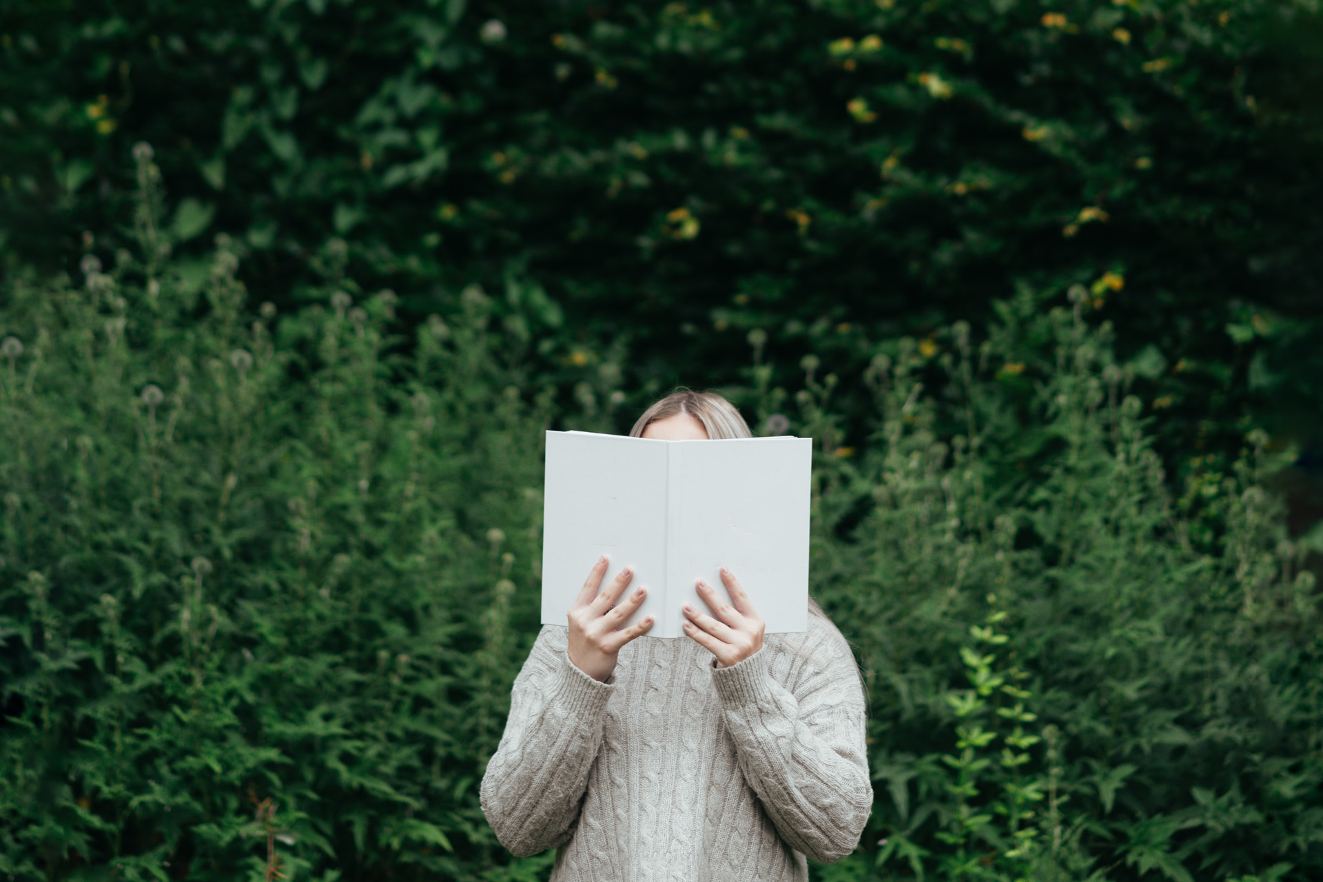 a woman holding a book in front of her face