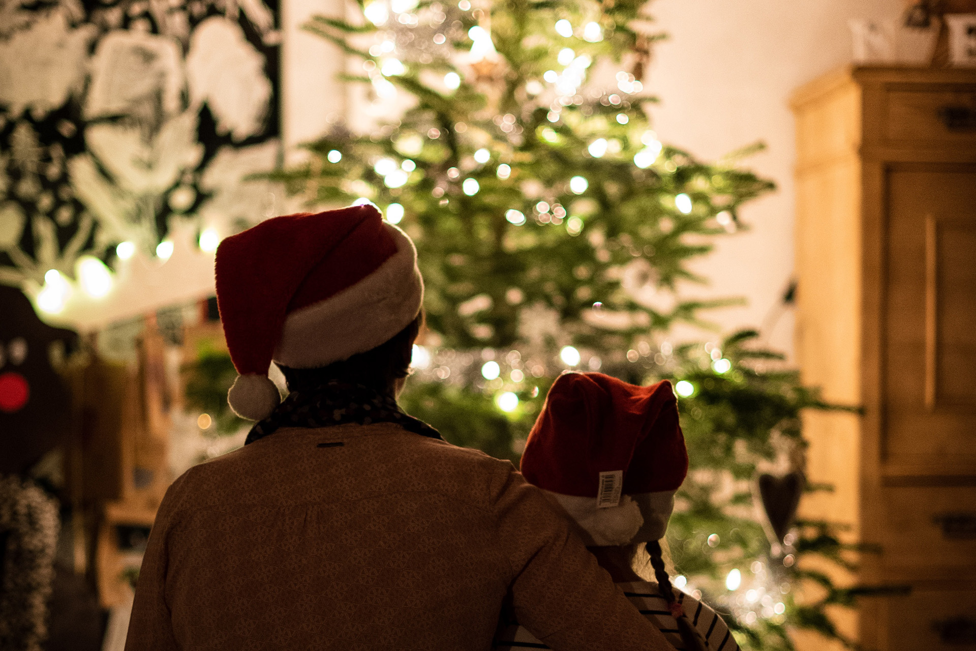 two people silhouetted against a christmas tree