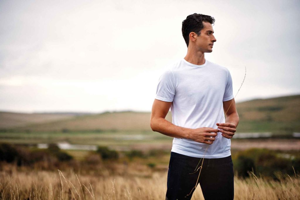 Man stood in field wearing white t-shirt