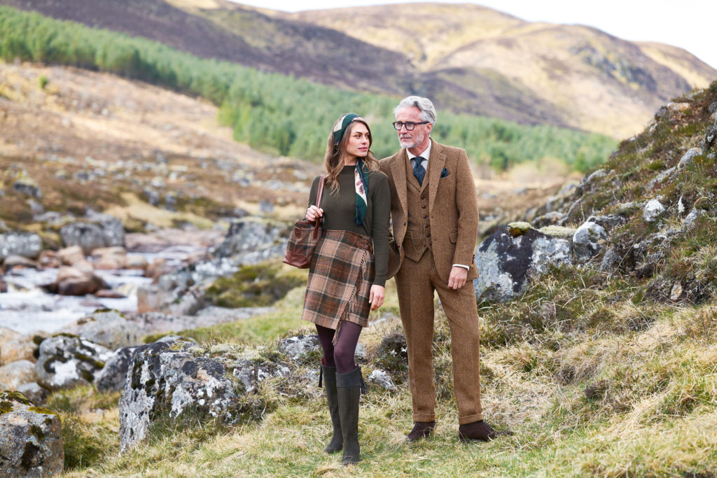 A man and a woman standing in a field in the Scottish Highlands