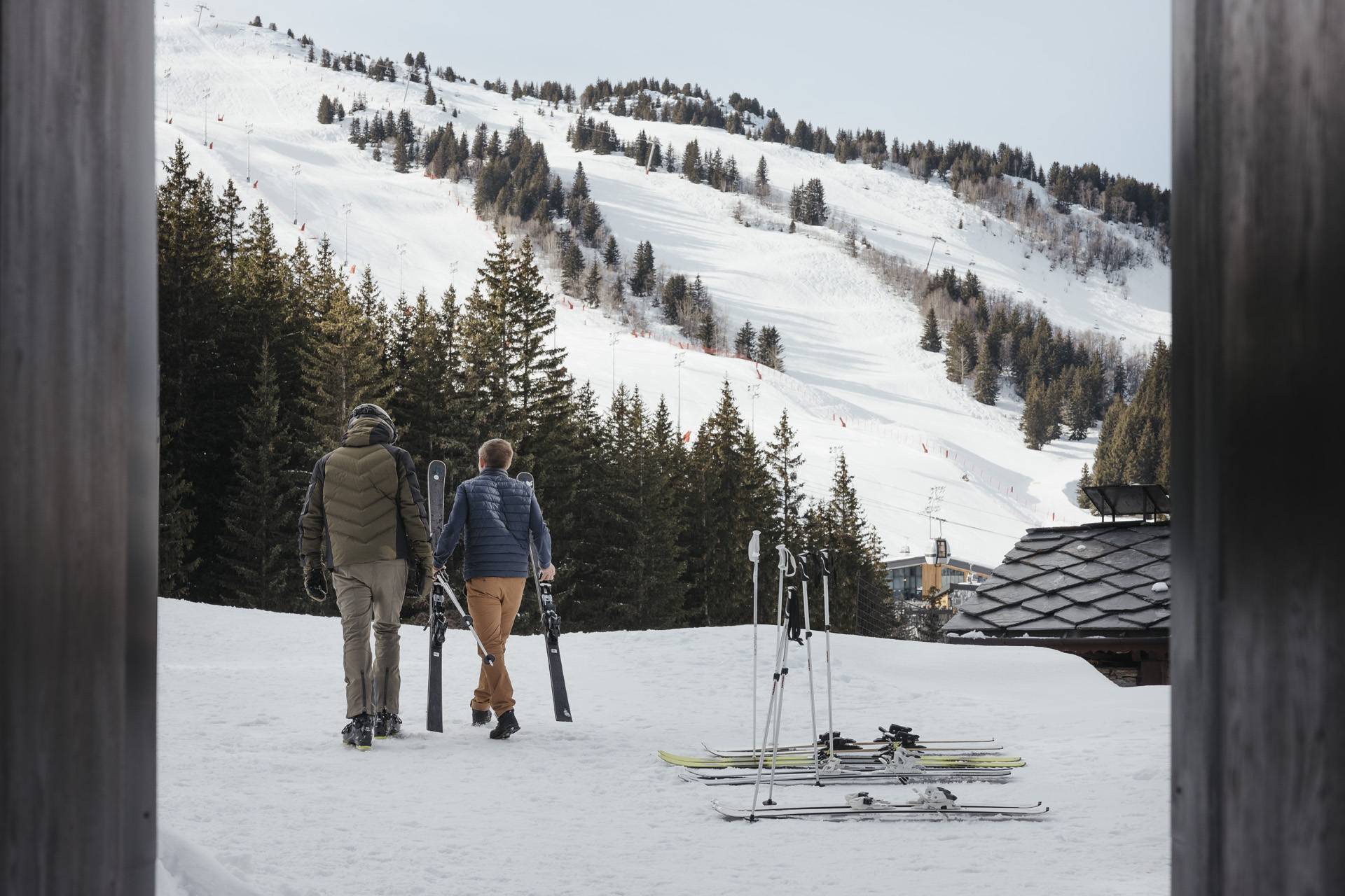 Two men walking with skis at Aman Le Melezin