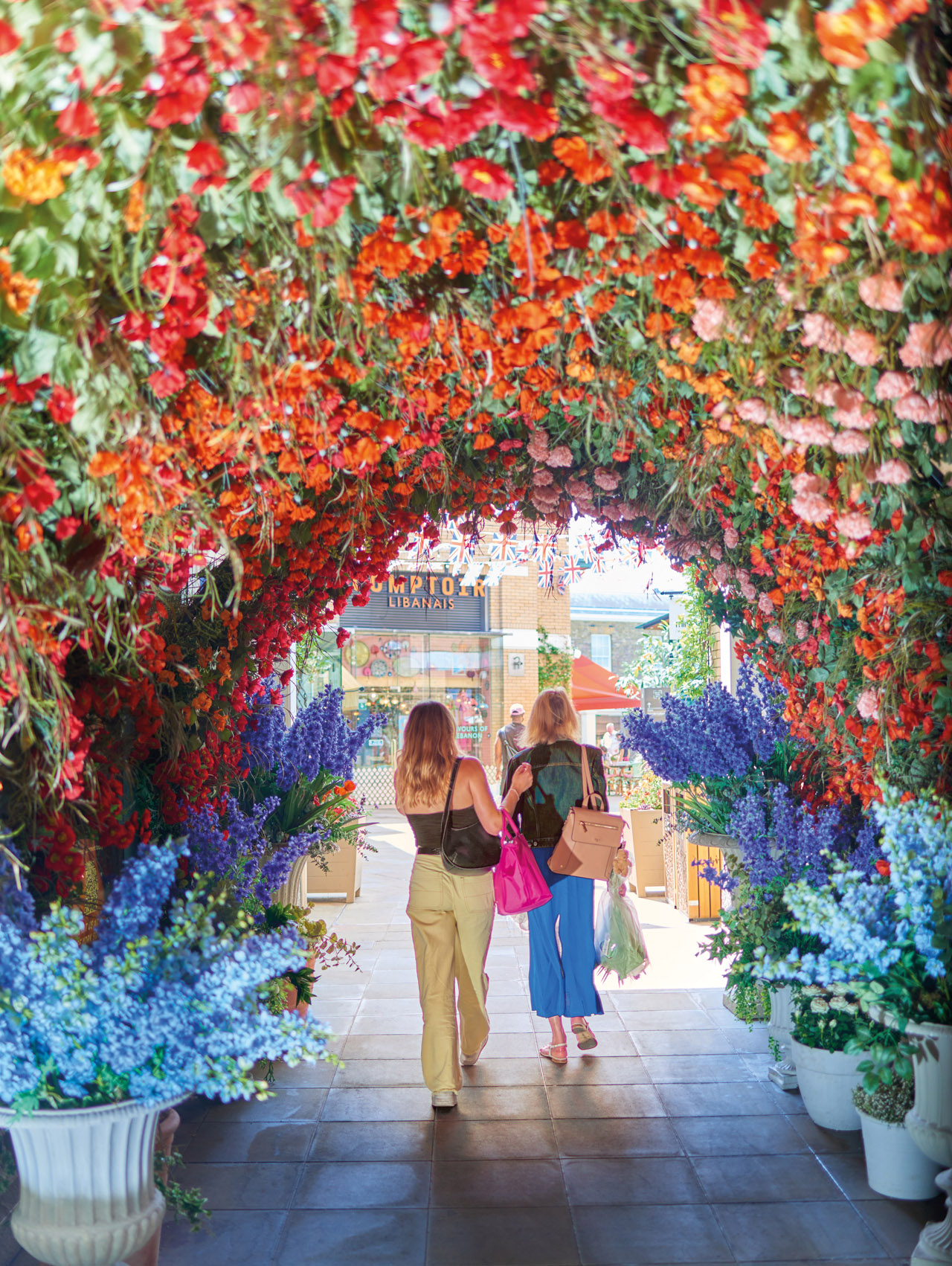 Two women walking under a flower arch on the Cadogan estate