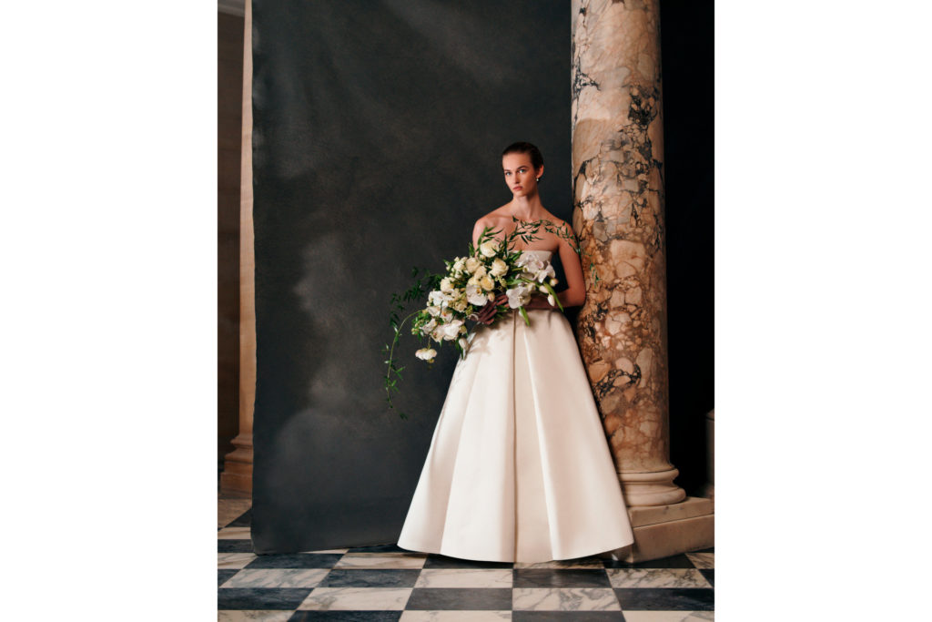 Woman in white dress holding flowers