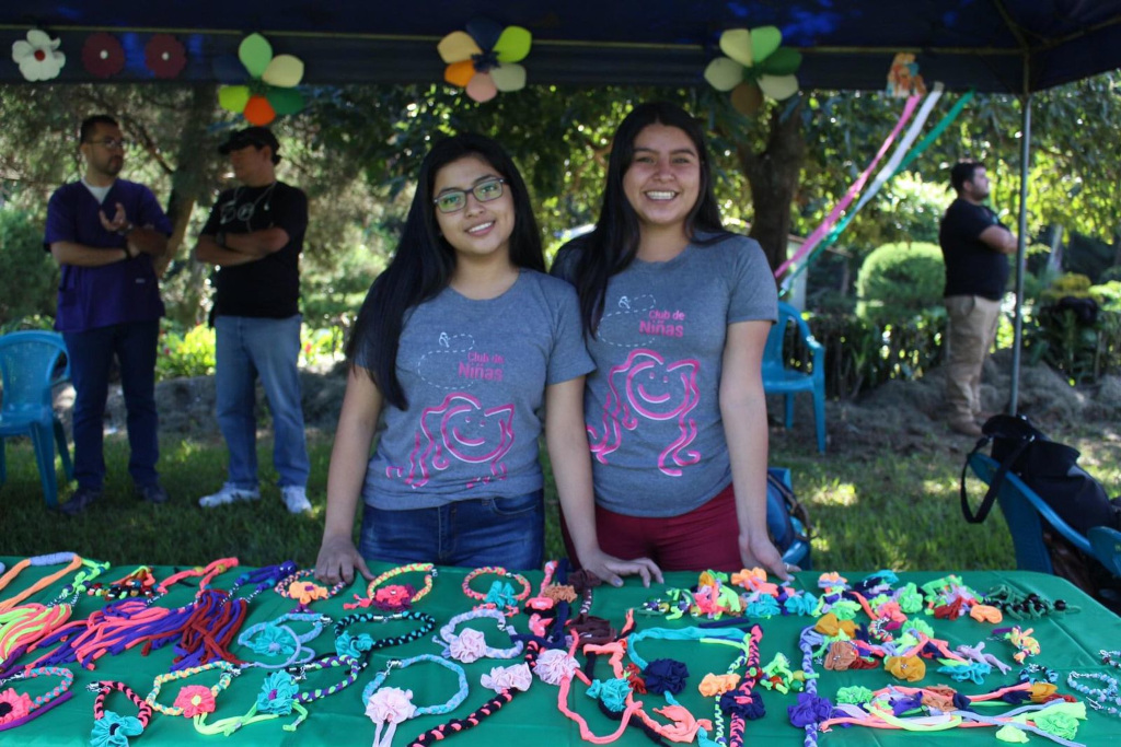 Two girls stood by stall with beaded jewellery