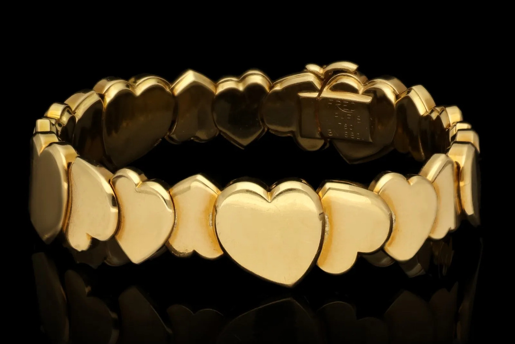 Gold heart bracelet on black background