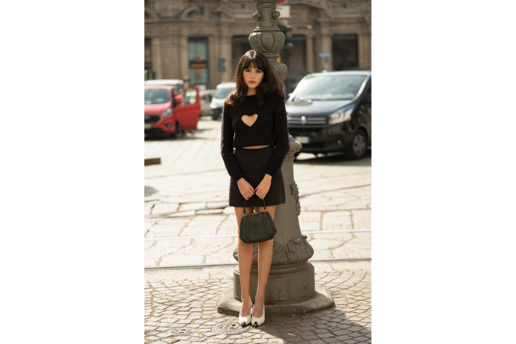 Woman on street in black jumper and skirt