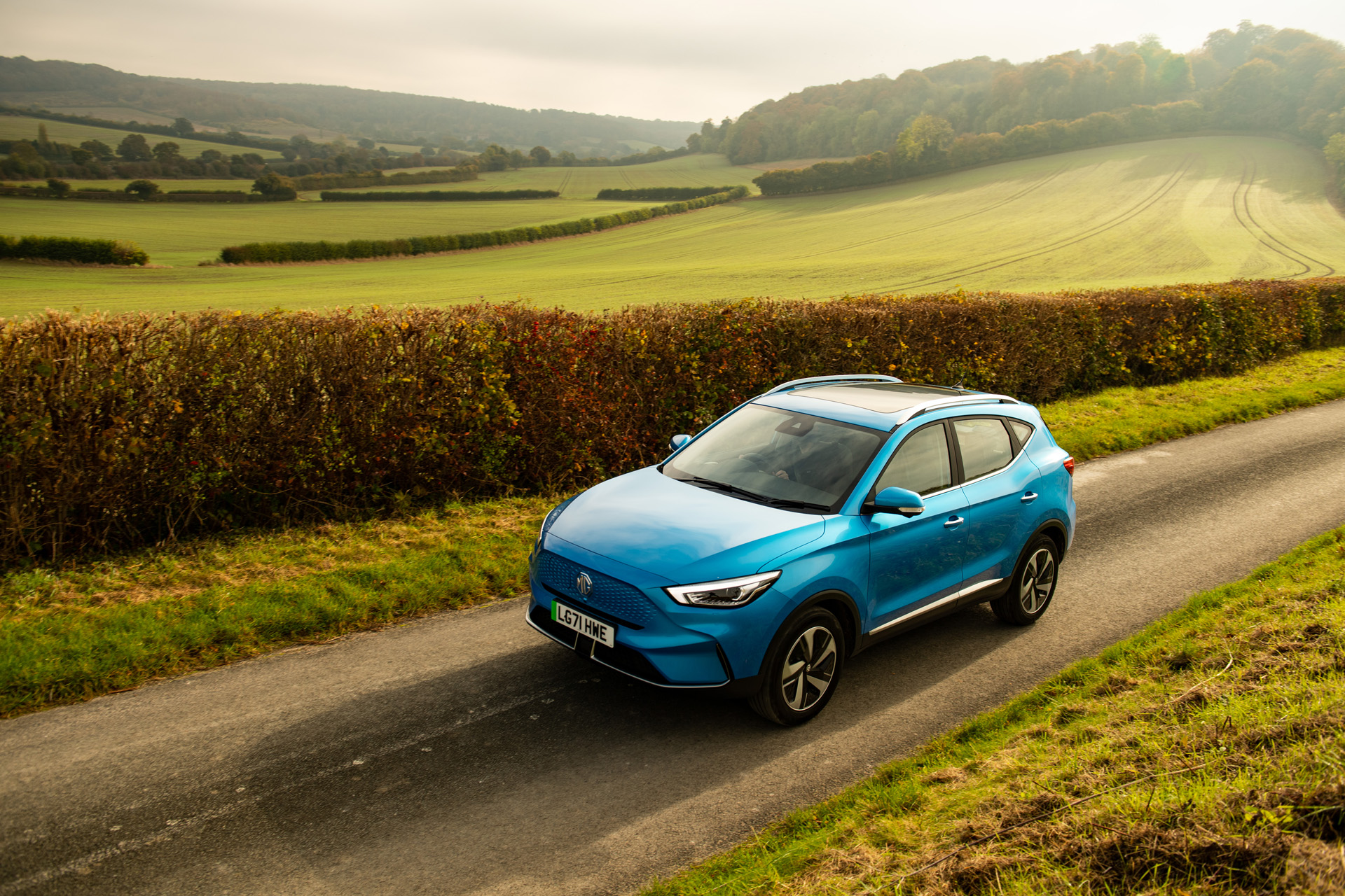 A blue MG ZS EV on a country road