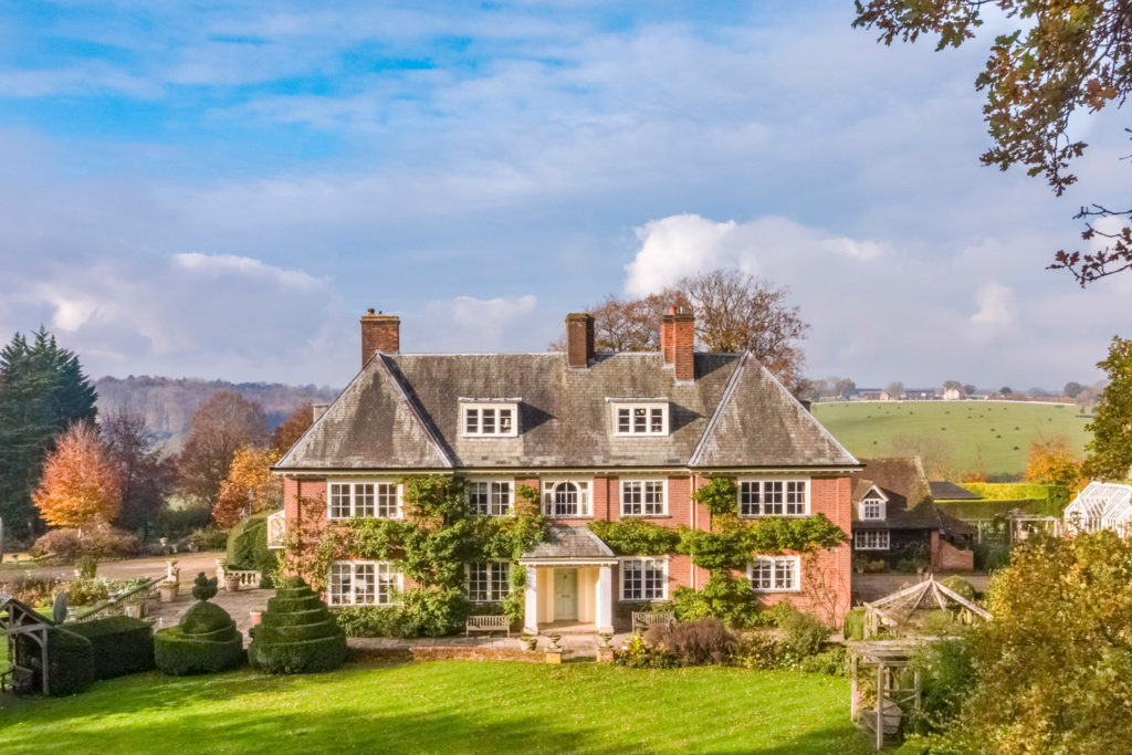 Cottage in Marlow with red brick exterior, ivy, and a large front garden.