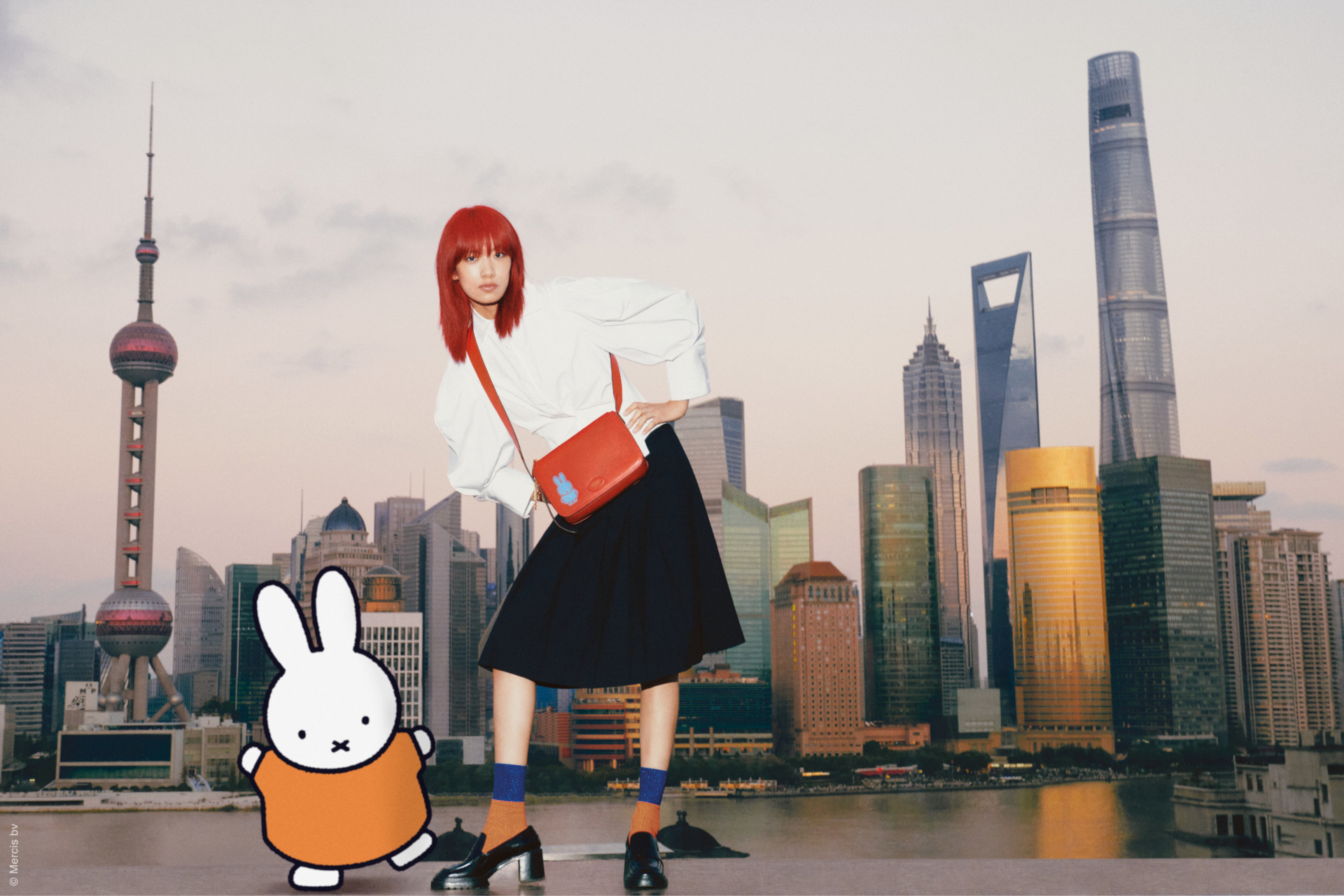 Woman with red hair stood in front of city skyline with Miffy character