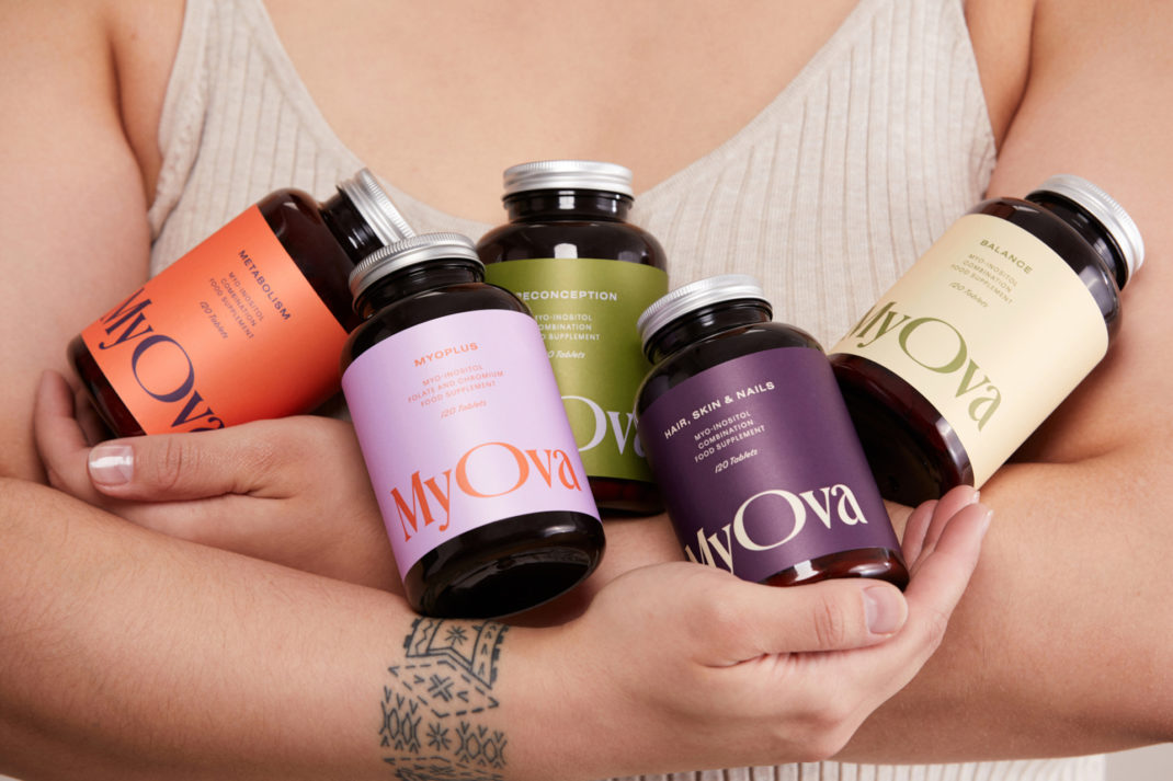 Close up arms holding multicoloured bottles of supplements | best supplements