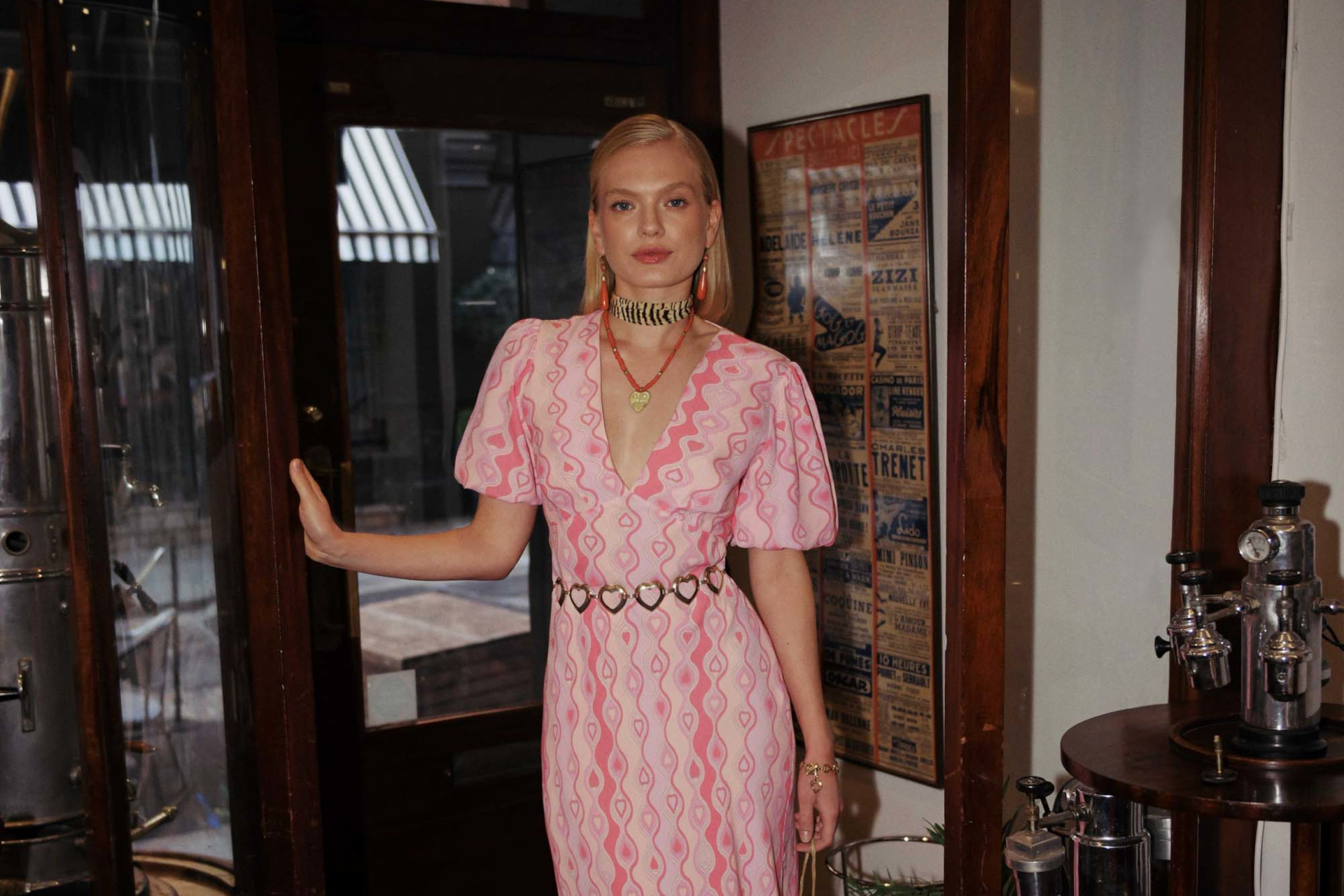 Woman stood in doorway wearing pink dress