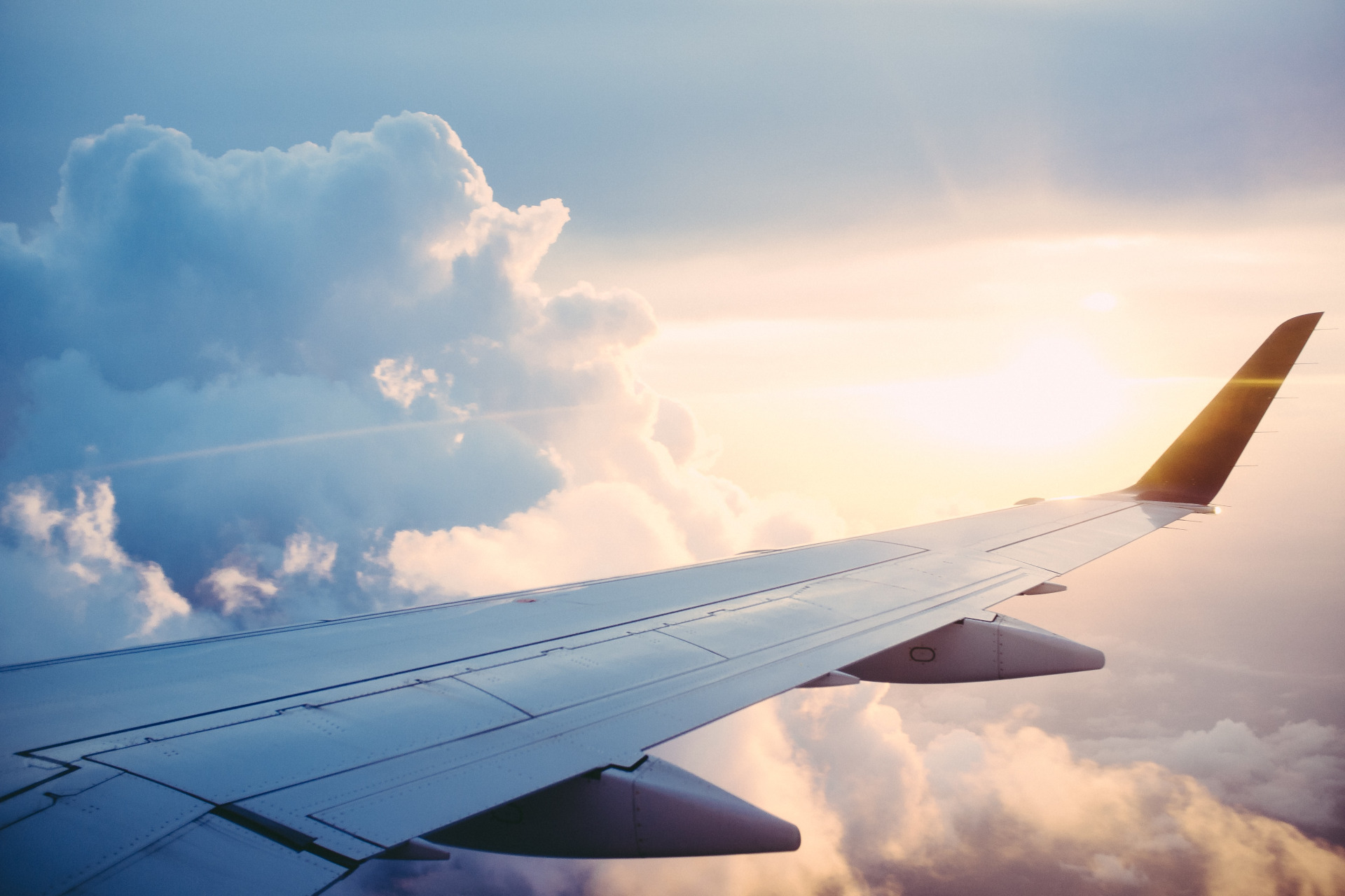 View of plane wing in the air at sunset