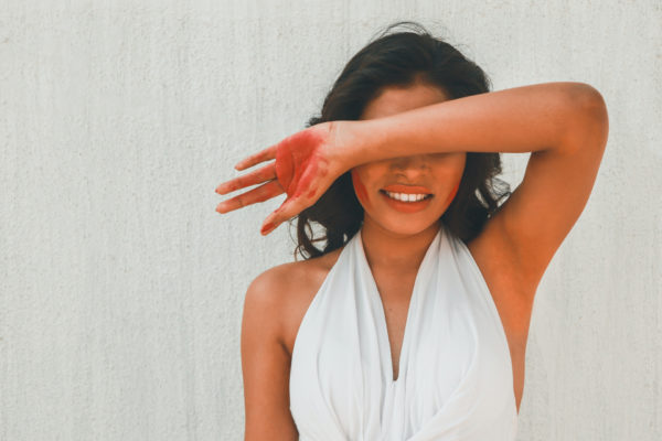 Woman with arm up covering her face