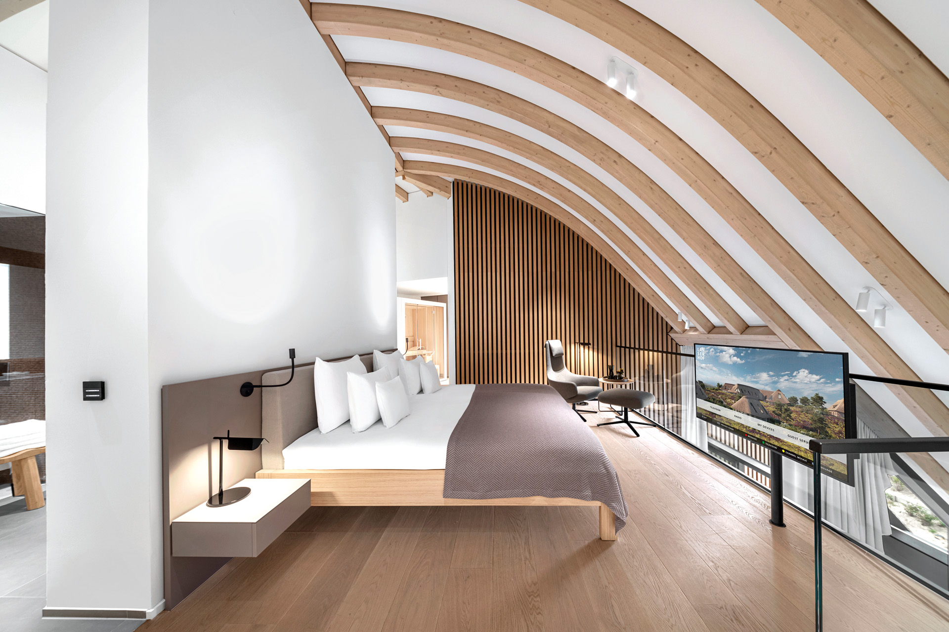 A suite with a TV and curved ceiling