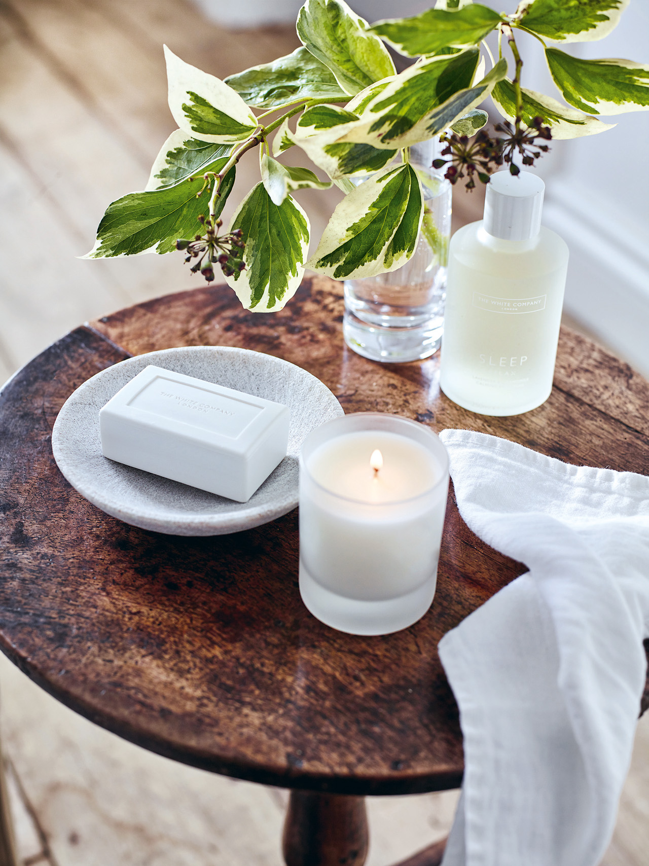 A side table with leaves and scents from The White Company