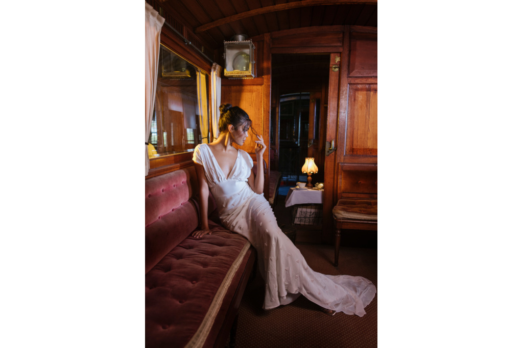 Woman in white dress sat on train