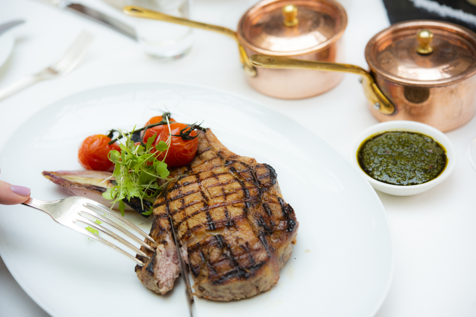 Close up of steak dinner on white plate and tablecloth