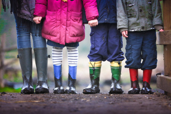 Four children stood together in coats and wellies