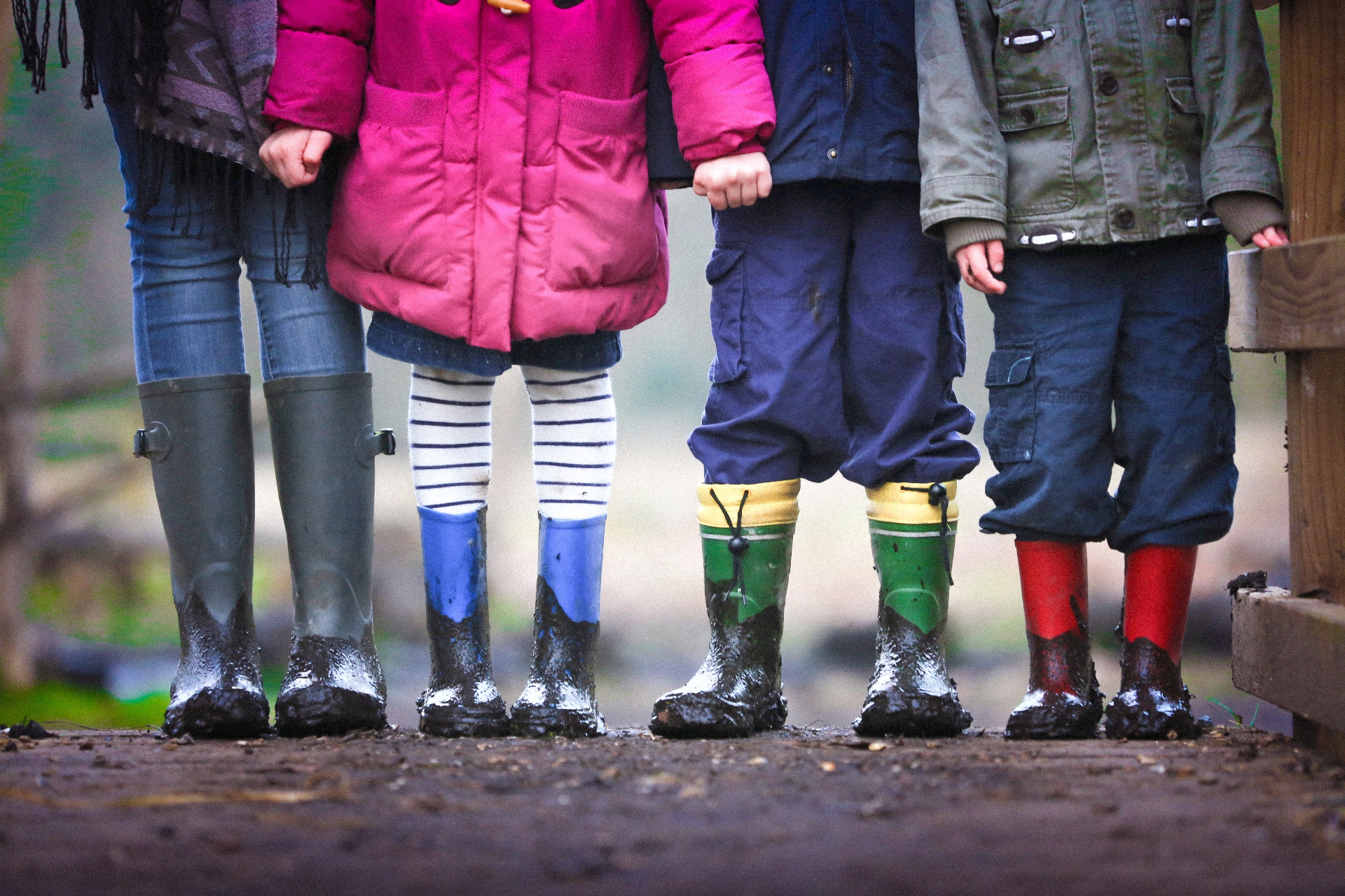 Four children stood together in coats and wellies