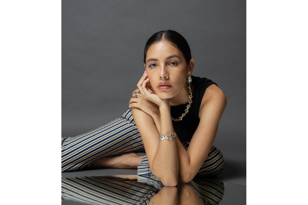 Woman laying on reflective surface wearing jewellery