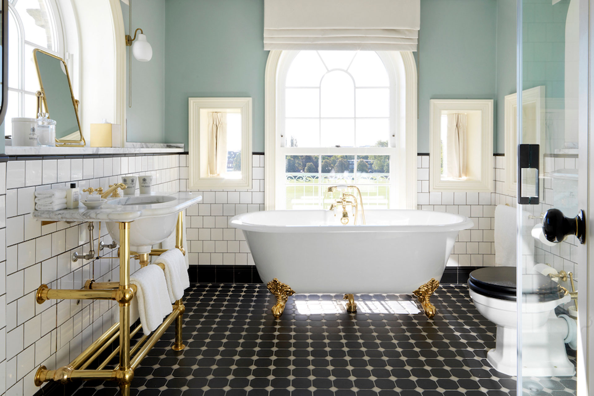 Bathroom at University Arms hotel with freestanding bath and large dome window.