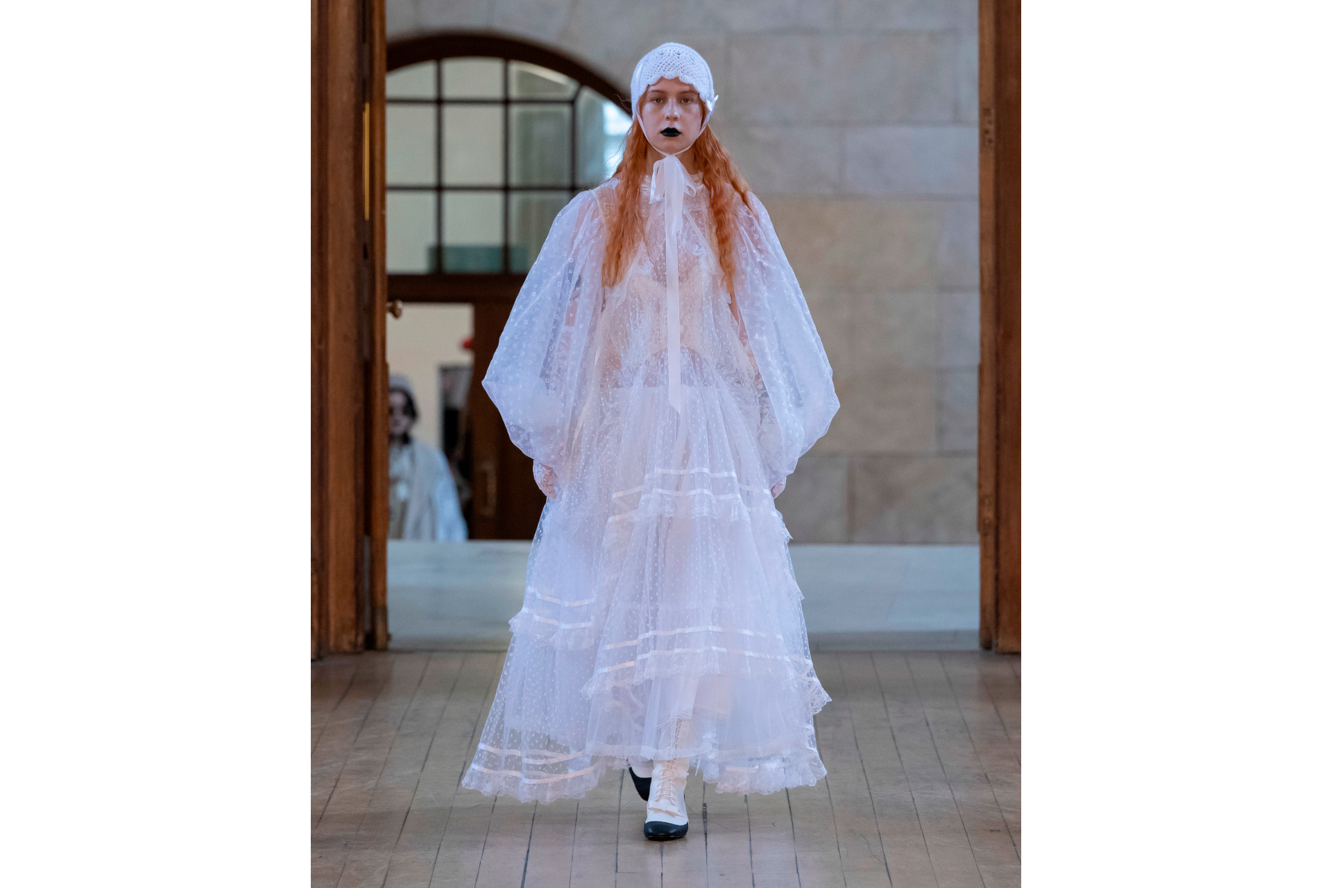 Woman in white sheer dress and cap
