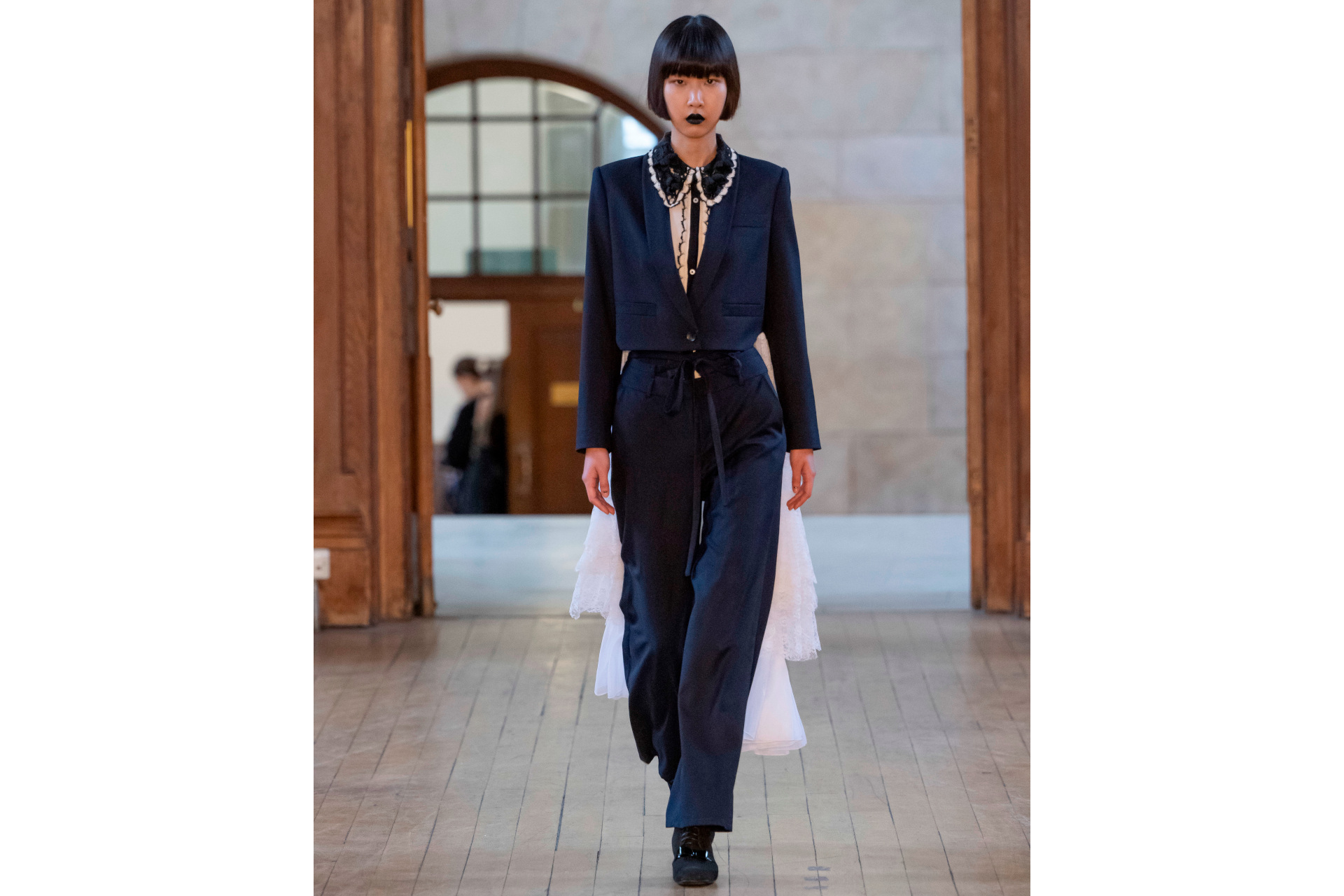 Woman in black suit with white train