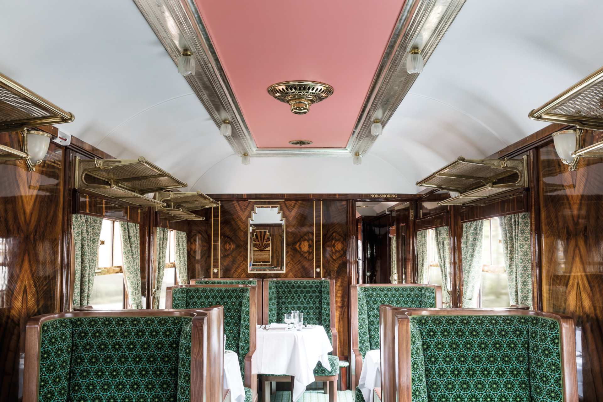 Train carriage with green seats and pink ceiling