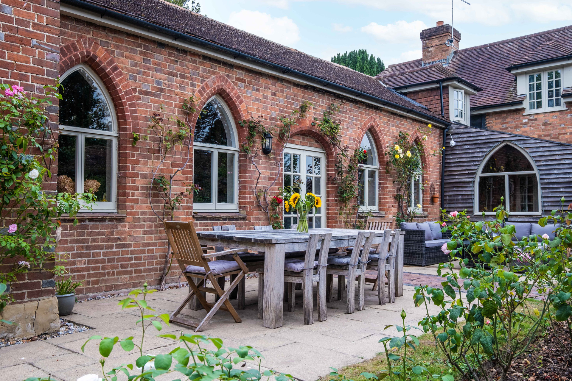 An outdoor dinner table surrounded by flowers