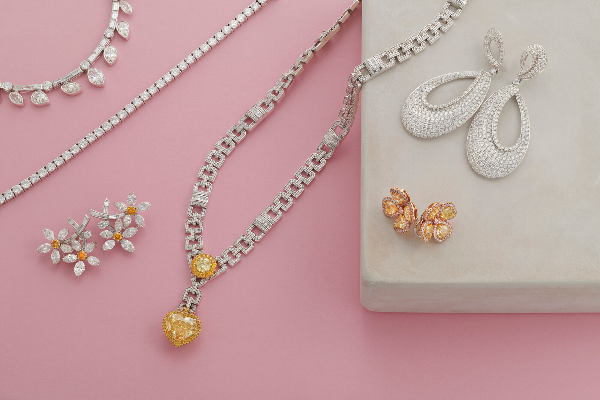 Jewellery laid out on pink surface