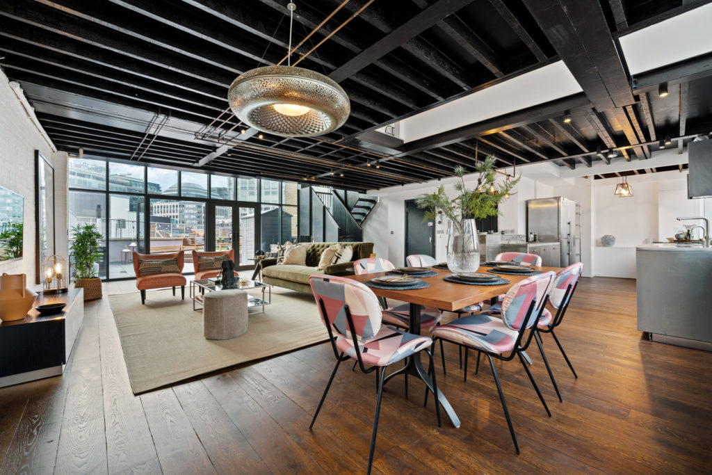 Large penthouse living room with steel-framed windows looking onto a roof terrace