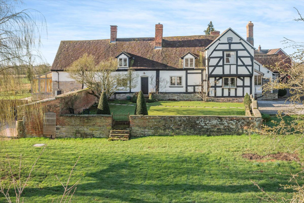 Large timber-framed manor house with fields in front
