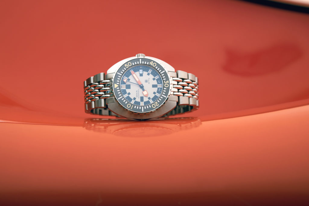 Stainless steel watch on orange background