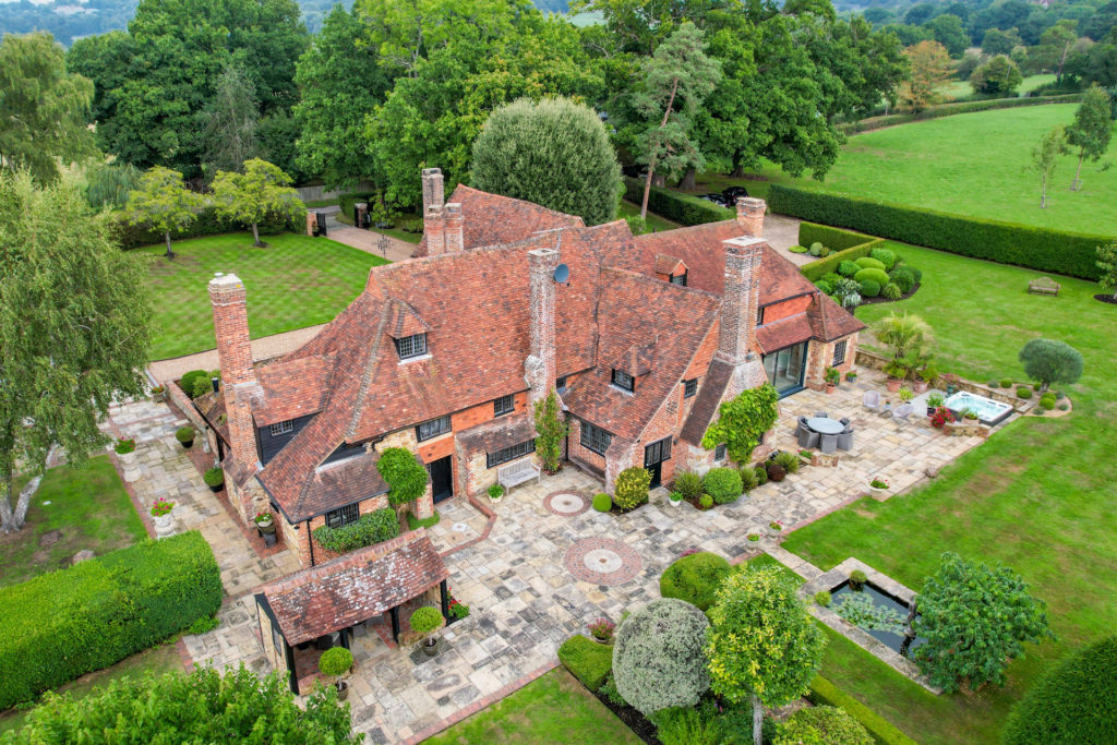 Exterior of large red brick country home with black window framing