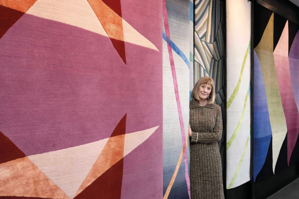 Deidre Dyson surrounded by rugs