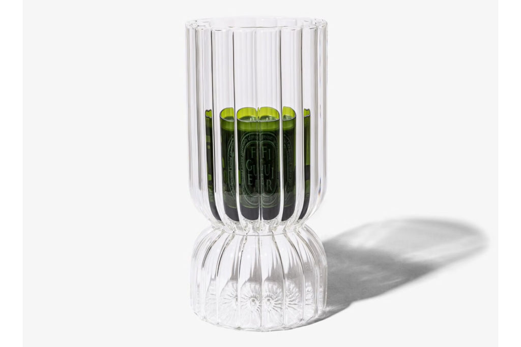Green Diptyque candle in fluted glass candle holder.